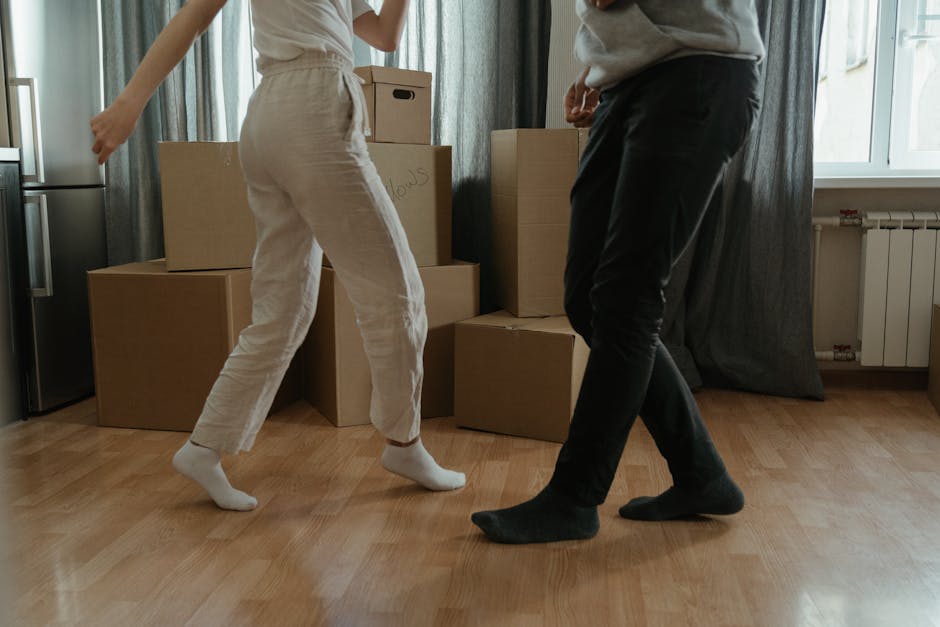 The image shows the open rear doors of a white van used for home relocation, revealing a neatly packed interior filled with various cardboard boxes of different sizes, some labeled with 'FRAGILE' stic
